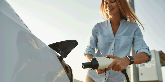 woman recharging electric vehicle