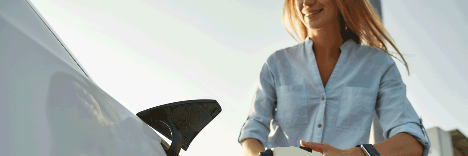 woman recharging electric vehicle